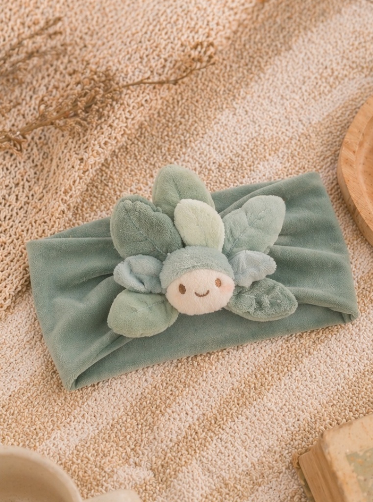Banda para bebé con muñeco botánico de hojas para colecciones naturales y fuerte atractivo visual en boutique