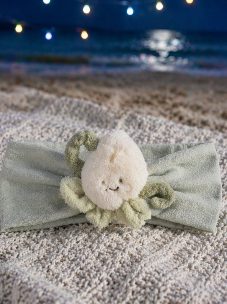 Baby-Headwrap mit flauschiger Samenfigur – sympathischer Regalauftritt und B2B-Potenzial