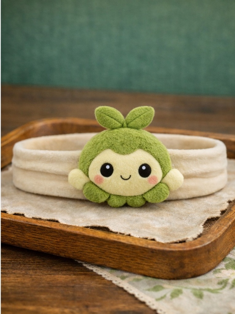 Faixa de bebê com boneco verde em pelúcia, ideal para vendas B2B